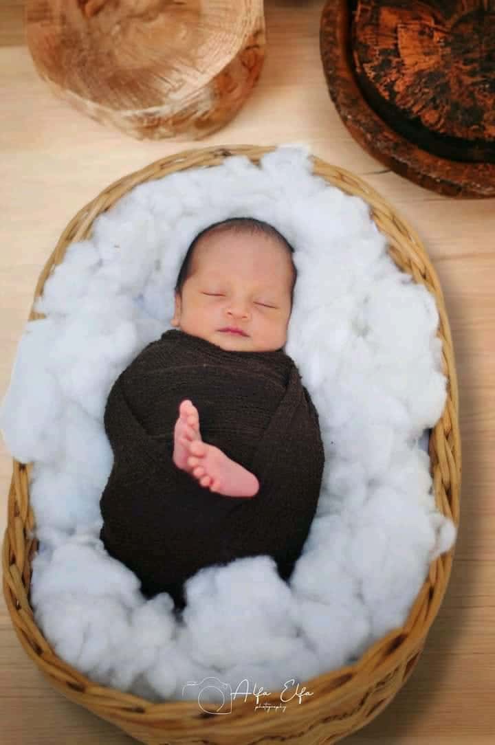 Foto newborn bayi tidur lelap di dalam keranjang kapas