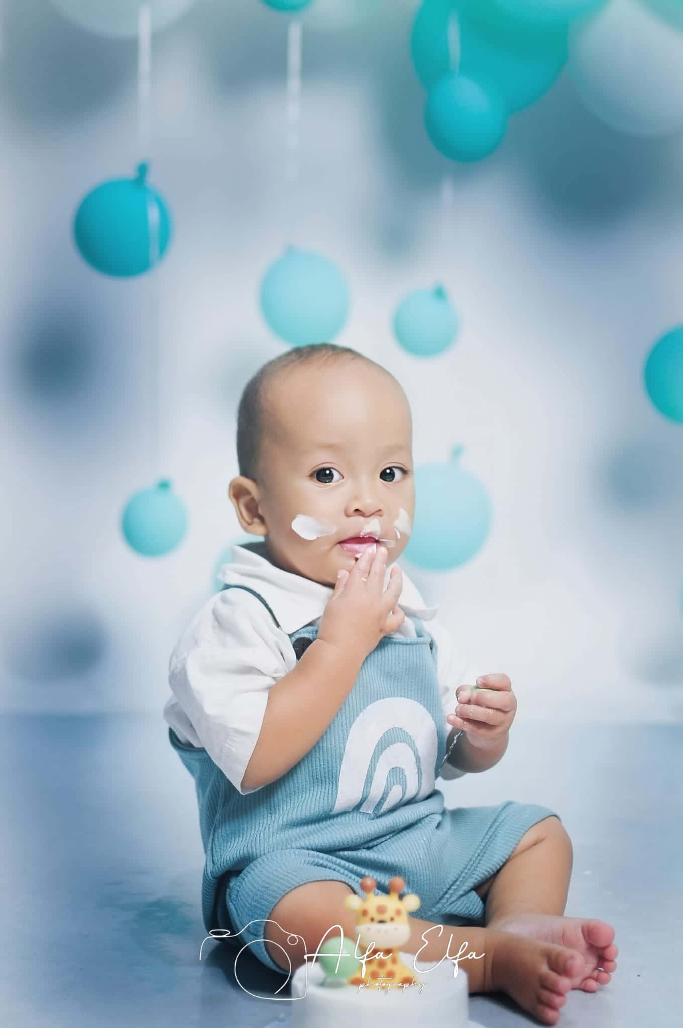 Foto bayi dengan properti balon biru gaya ceria