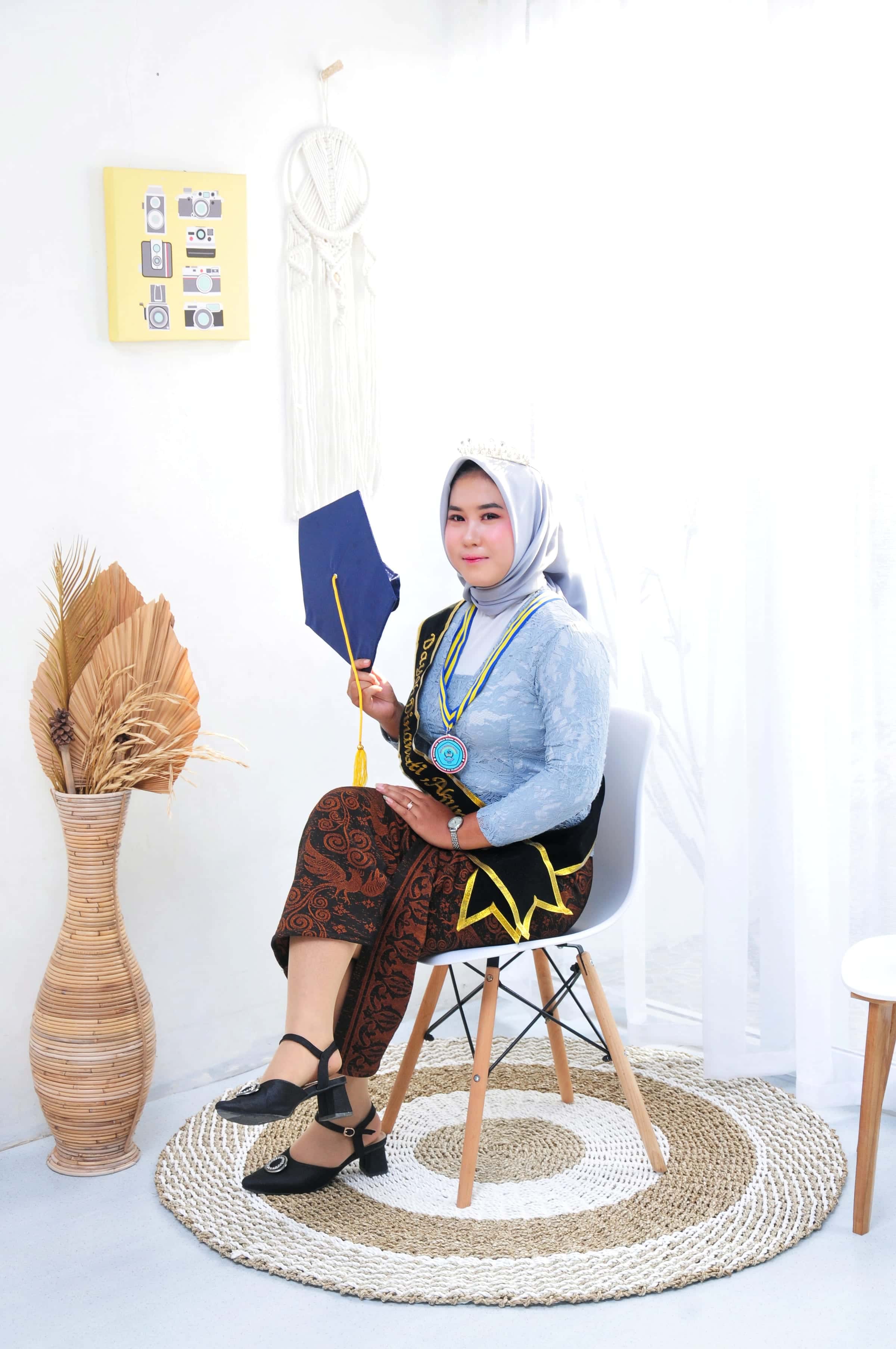 Self studio wanita duduk santai dengan dekorasi kipas dan rotan