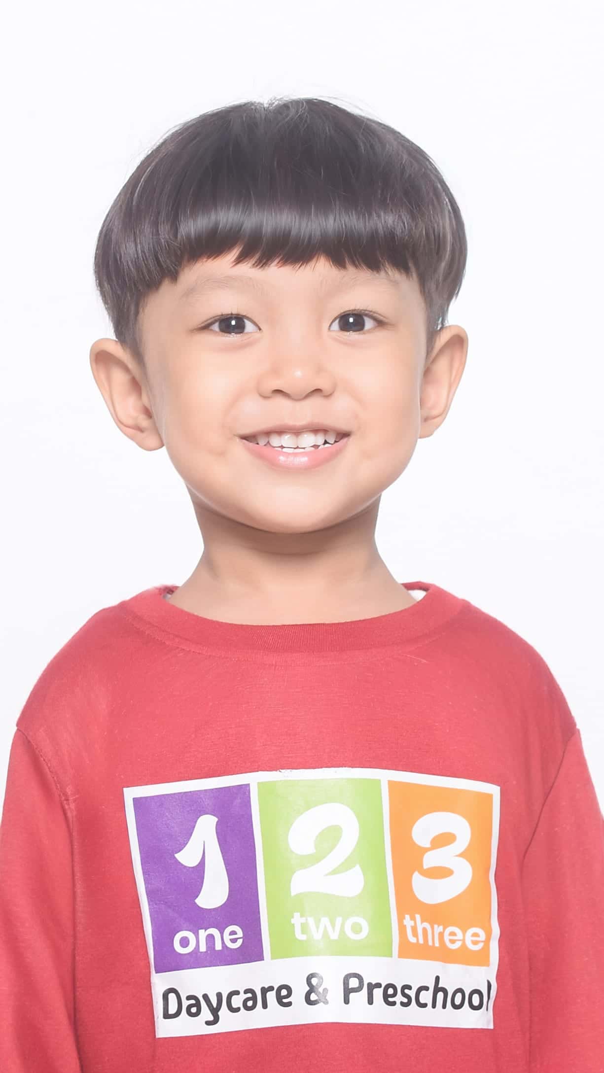 Self studio anak laki-laki tersenyum busana kasual merah