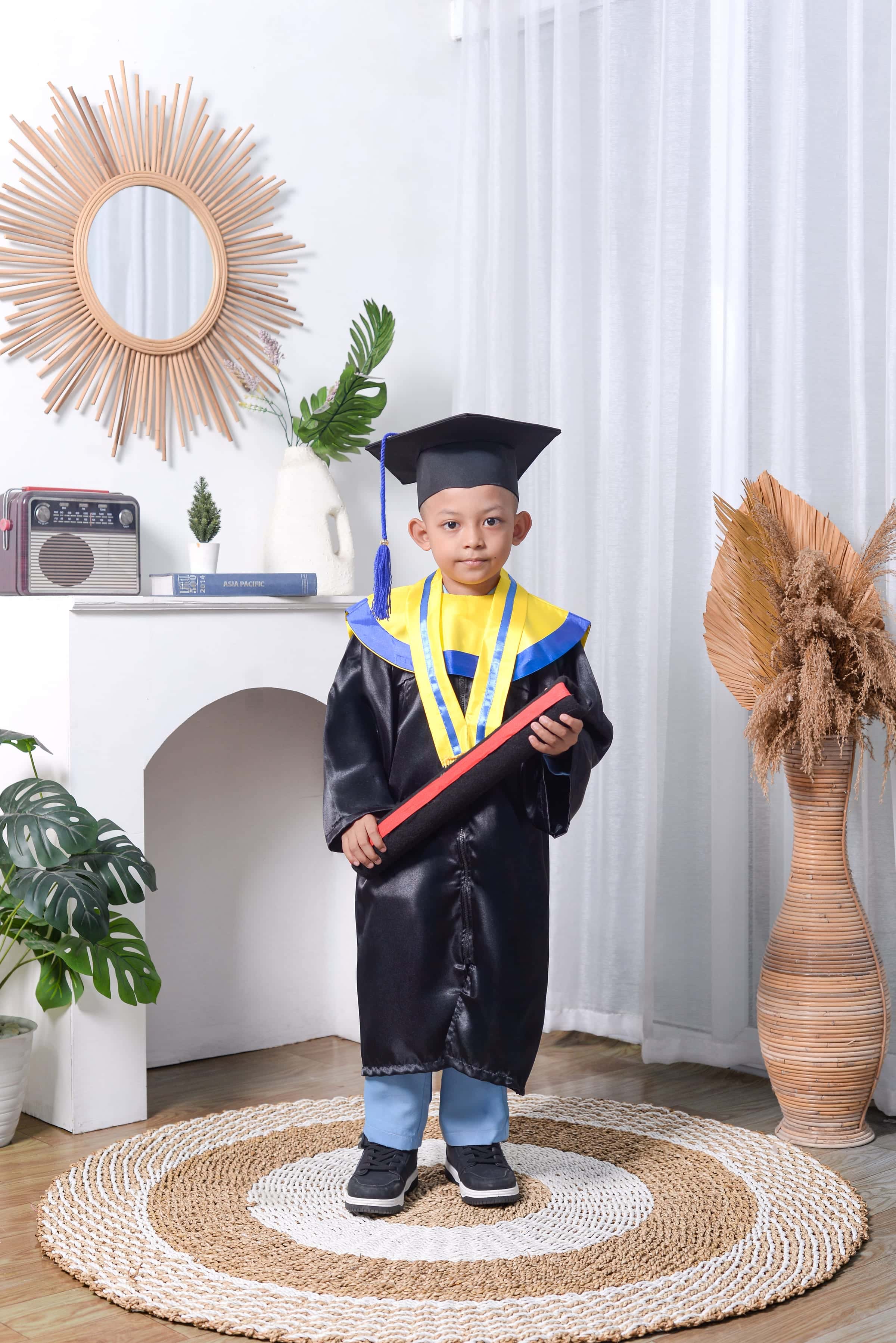 Foto wisuda TK anak laki-laki toga lengkap dengan properti kelulusan
