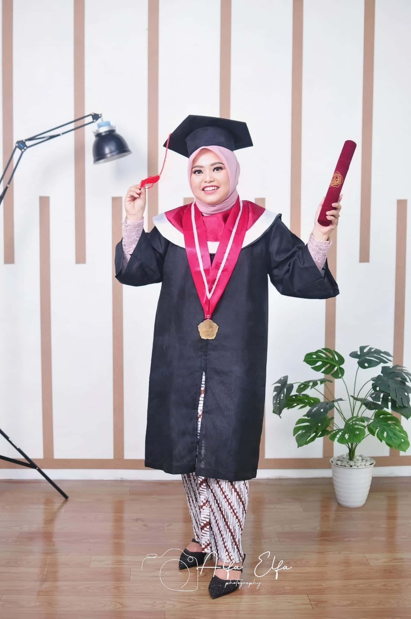 Foto wisuda wanita toga lengkap dengan bunga dan medali kelulusan
